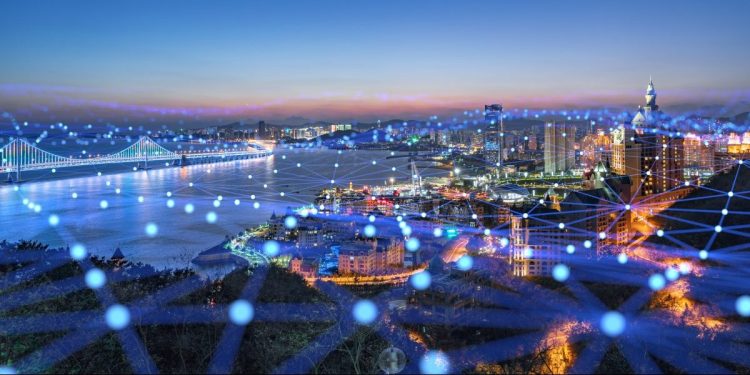 Image of city during dusk. All of the buildings are connected by an overlay of digital infrastructure.