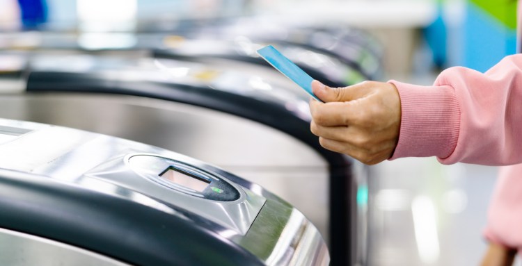Woman hand scanning train ticket to subway entrance gate. Transportation concept
