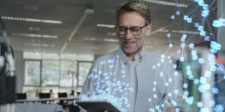 Image of man holding a tablet with images of code and AI-led security measures floating in foreground.