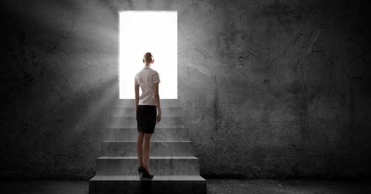 Silhouette of business person with briefcase standing in doorway