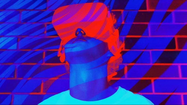 Person a white t-shirt wearing virtual reality Headset in Neon fluorescent ultra violet purple and blue colors