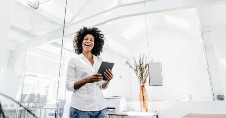 Happy person in office holding tablet