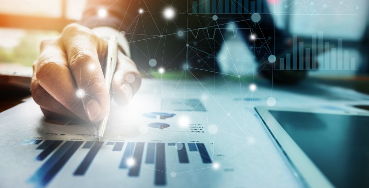 Close up business person hand holding pen and pointing at financial paperwork with network diagram.