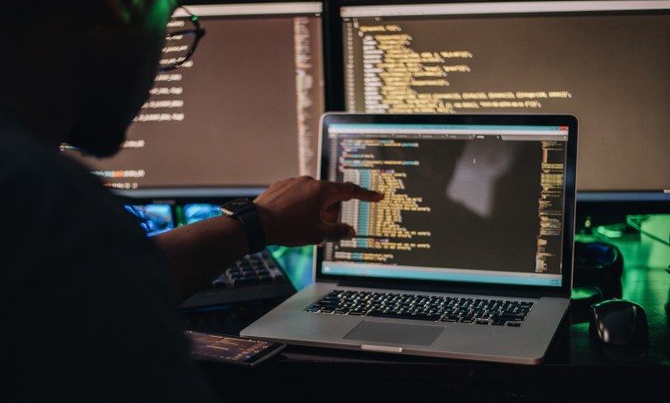 pointing at code on computer screen