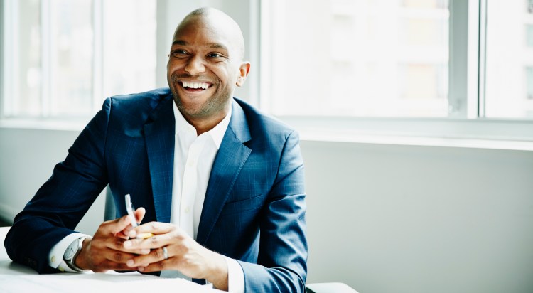 Smiling CISO in discussion at security workstation in office