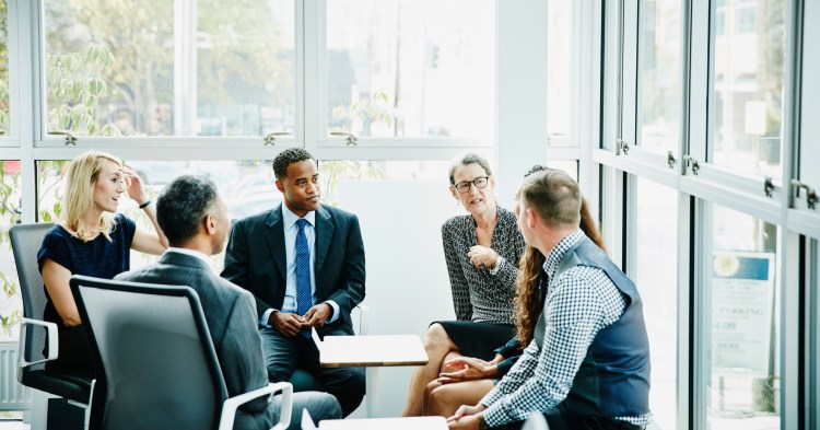 Business woman leading team meeting in conference room