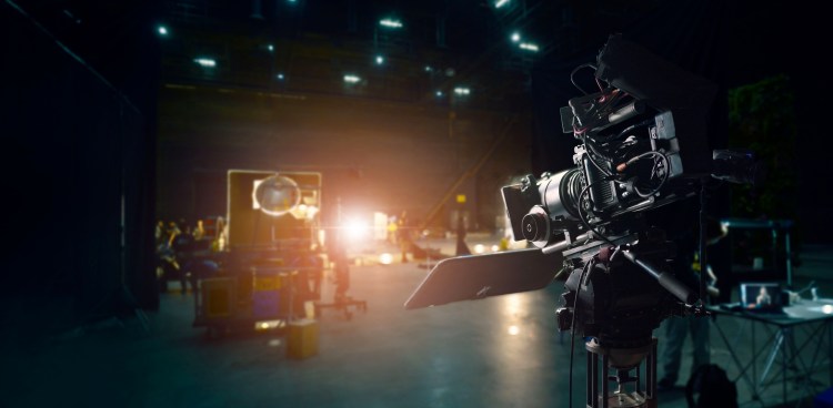 Behind the scenes of making of movie and TV commercial. Camera of movie and video production. Film Crew. B-roll, and crew team in studio and set on dark background