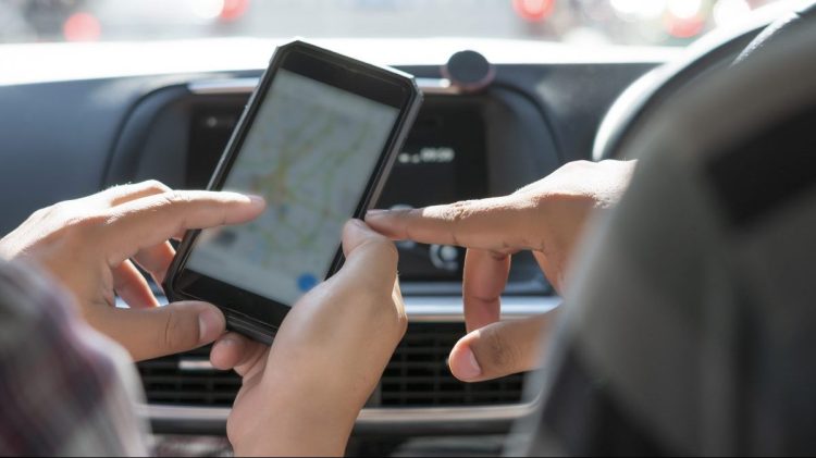 Cropped shot of hand tourists are searching for a way on the map in the application on car.
