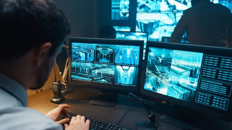 Security guard watching video monitoring surveillance security system.