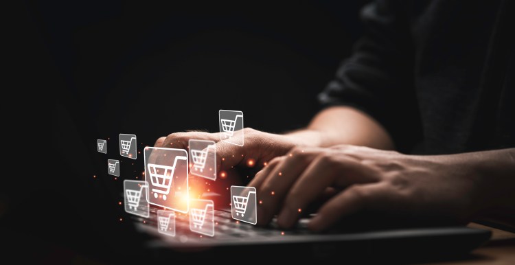 Person using computer laptop with shopping cart icon for input order for online shopping/ecommerce/supply chain management concept.