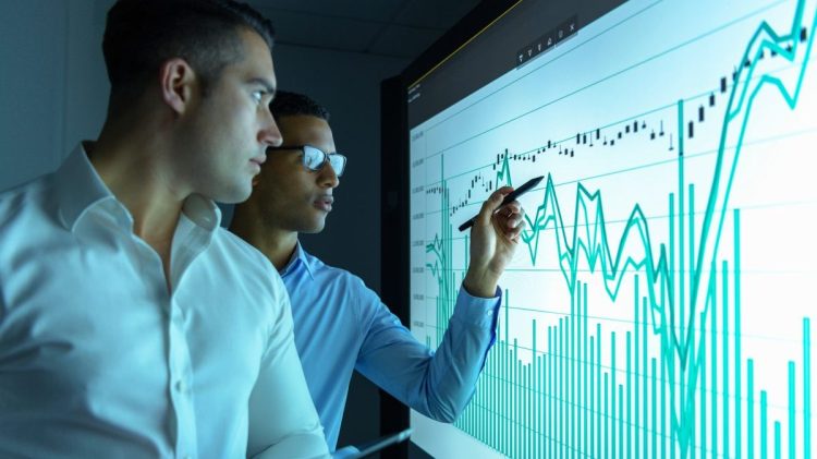 Businessmen studying graphs on an interactive screen in business meeting. Data analysis concept