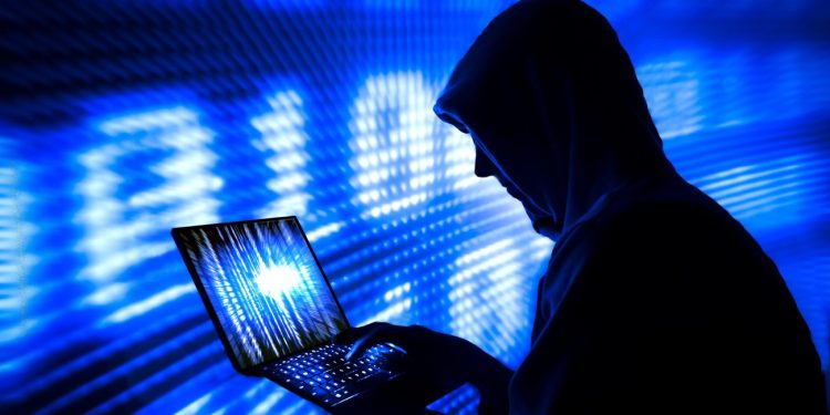 Hooded adult man cyber criminal