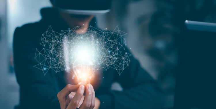 Man wearing VR glasses virtual and holding light bulb with icons and working on the desk, Creativity and innovation are keys to success.Concept  new idea and innovation with energy and power,Metaverse