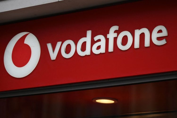 Branding for Vodafone is pictured outside a store in west London on May 15, 2022.