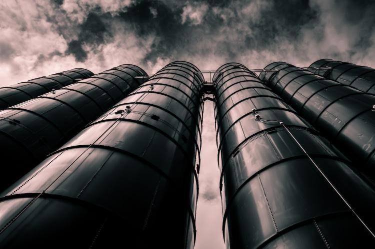 picture of several black silos as taken from the ground looking up; representing data silos