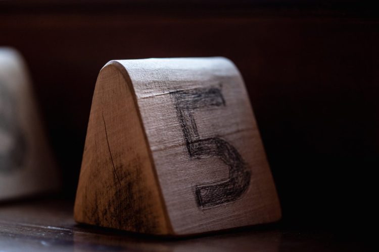 A wooden block with the number 5 written on it