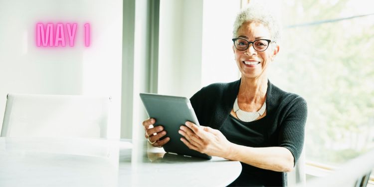 May 1 dated image of smiling person holding notebook