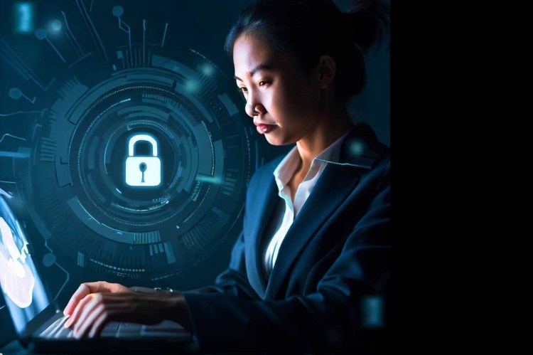 A woman in a business suite typing on a computer keyboard with a light padlock symbol behind her, representing cybersecurity.
