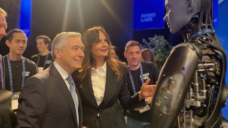 Canada's Minister of Innovation, Science and Industry François-Philippe Champagne (left) looks along with other people at a robot.